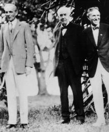 Thomas Edison standing with Henry Ford and Harvey Firestone.