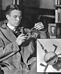 Ernest Orlando Lawrence holds up a cyclotron model