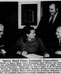 Evelyn Berezin pictured signing a document with three men from a Philadelphia Inquirer newscliping